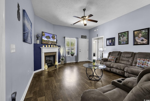 living area featuring a fireplace with flush hearth, baseboards, a ceiling fan, and wood finished floors