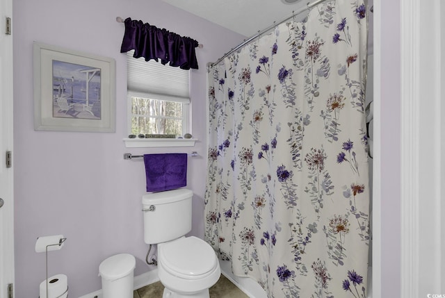 bathroom featuring tile patterned floors, toilet, baseboards, and a shower with curtain