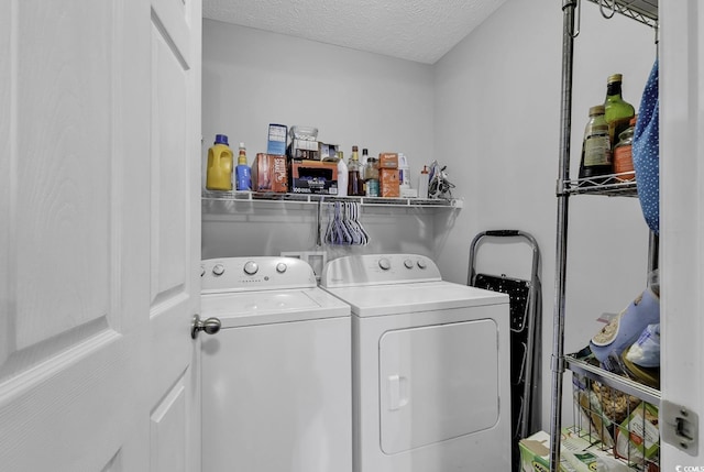 washroom featuring washing machine and dryer, a textured ceiling, and laundry area