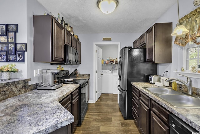 kitchen featuring dark brown cabinets, a sink, washer and clothes dryer, and black appliances