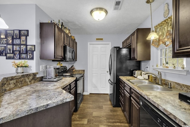 kitchen featuring dark wood finished floors, dark brown cabinets, visible vents, a sink, and black appliances