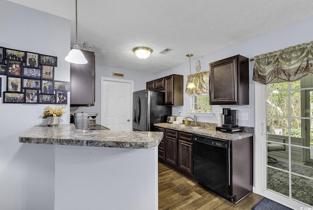 kitchen featuring dark wood-style floors, a sink, freestanding refrigerator, dark brown cabinetry, and black dishwasher