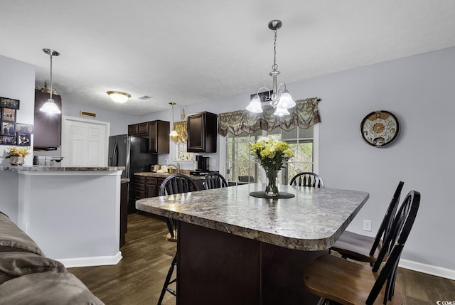 dining space featuring baseboards, dark wood-style floors, and an inviting chandelier