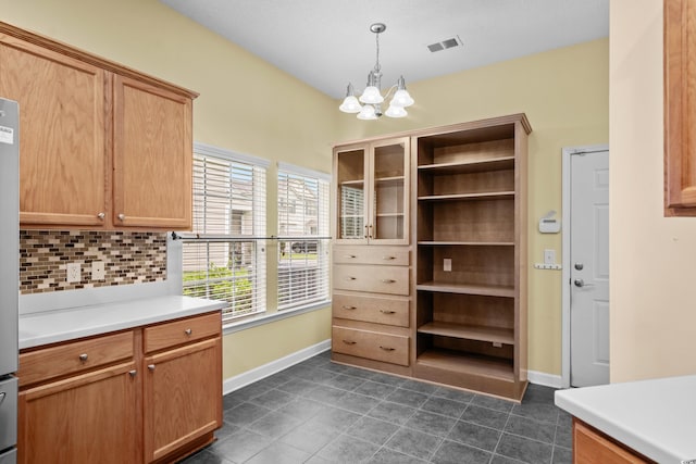 1205 Woodruff Ct, Conway, SC 29526 - kitchen with a chandelier, decorative backsplash, light countertops, hanging light fixtures, and dark tile patterned floors