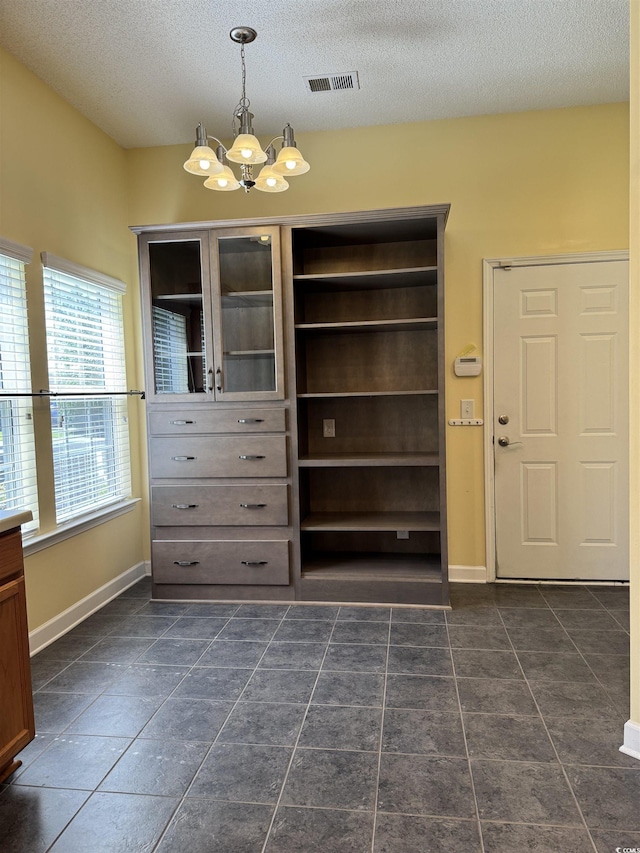 1205 Woodruff Ct, Conway, SC 29526 - unfurnished dining area with a chandelier, a textured ceiling, baseboards, and dark tile patterned floors