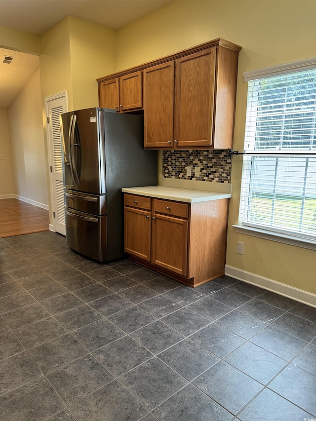 1205 Woodruff Ct, Conway, SC 29526 - kitchen featuring stainless steel fridge, baseboards, brown cabinets, backsplash, and light countertops
