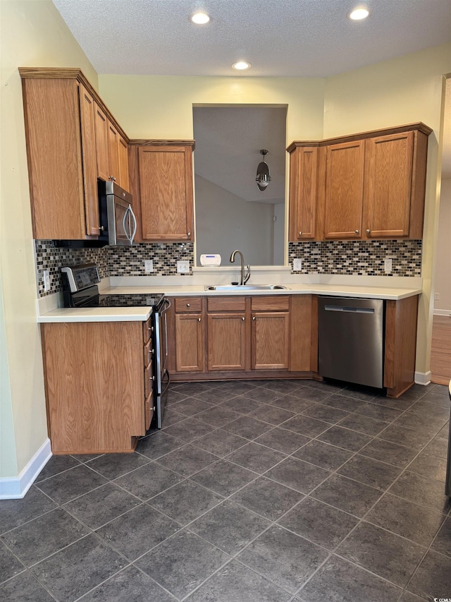 1205 Woodruff Ct, Conway, SC 29526 - kitchen with stainless steel appliances, a sink, decorative backsplash, brown cabinets, and light countertops