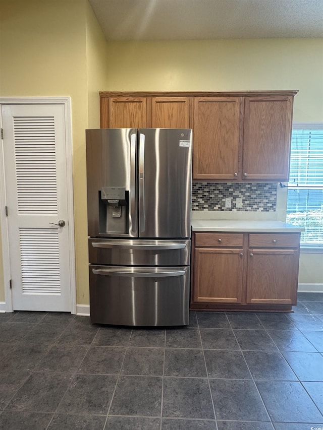 1205 Woodruff Ct, Conway, SC 29526 - kitchen with stainless steel fridge with ice dispenser, light countertops, decorative backsplash, baseboards, and brown cabinets