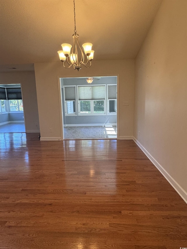 1205 Woodruff Ct, Conway, SC 29526 - unfurnished dining area with a chandelier, dark wood-style floors, a textured ceiling, and baseboards