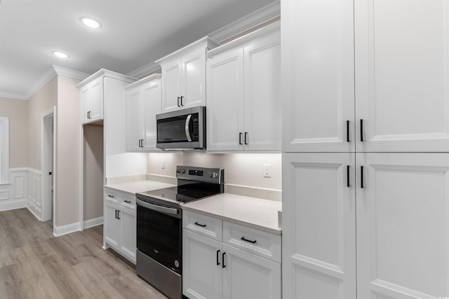 3329 Hughes Gasque Rd, Aynor, SC 29511 - kitchen with appliances with stainless steel finishes, light wood finished floors, crown molding, white cabinetry, and recessed lighting