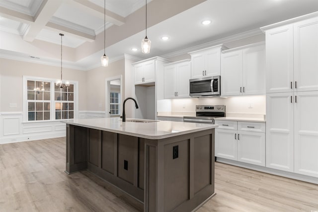 3329 Hughes Gasque Rd, Aynor, SC 29511 - kitchen with appliances with stainless steel finishes, beamed ceiling, light wood-style flooring, white cabinets, and light countertops