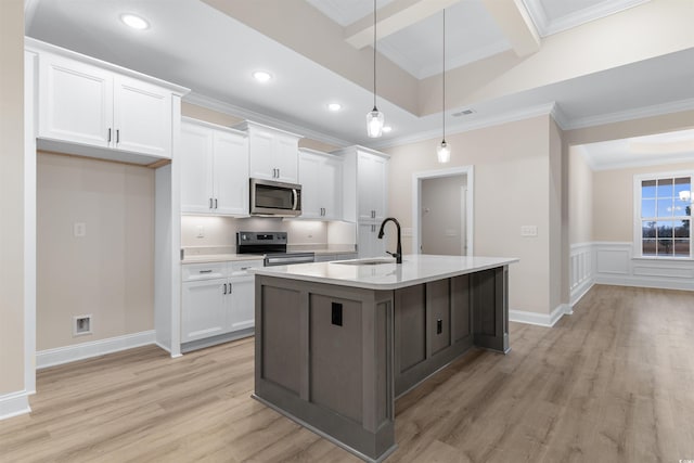 3329 Hughes Gasque Rd, Aynor, SC 29511 - kitchen featuring appliances with stainless steel finishes, white cabinetry, light wood-type flooring, a center island with sink, and crown molding
