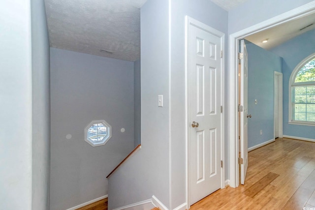 6001-1527 S Kings Hwy, Myrtle Beach, SC 29575 - hallway with baseboards, an upstairs landing, light wood-style floors, and visible vents