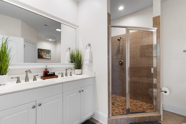 full bathroom with double vanity, a sink, visible vents, and a shower stall