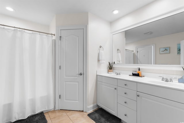 bathroom with double vanity, tile patterned floors, visible vents, and a sink