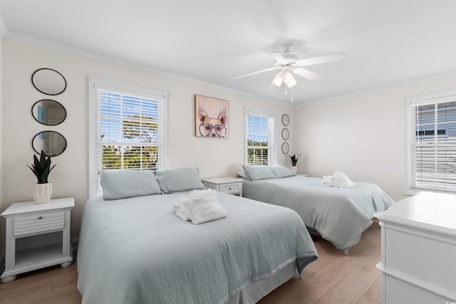 bedroom with ornamental molding, light wood-type flooring, and ceiling fan