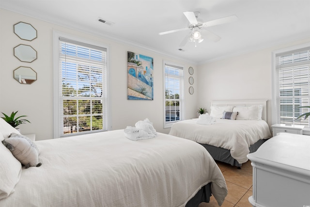 bedroom with light tile patterned floors, ornamental molding, and multiple windows