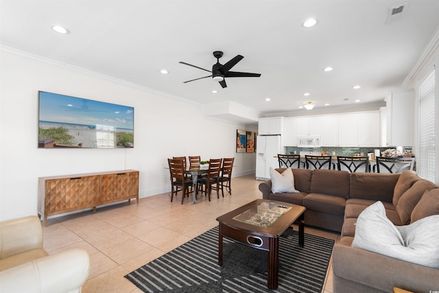 living room with crown molding, ceiling fan, light tile patterned flooring, and visible vents
