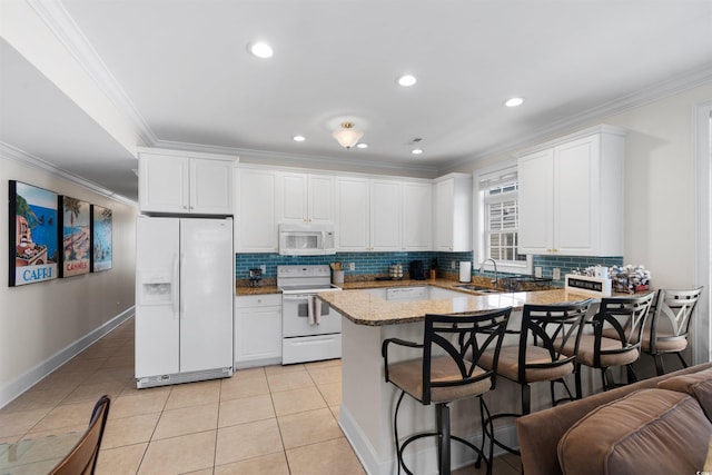 kitchen with decorative backsplash, white appliances, and white cabinetry