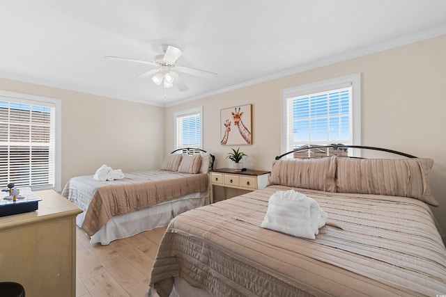 bedroom with light wood-style floors, ornamental molding, and ceiling fan