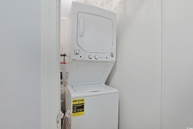 clothes washing area with laundry area and stacked washing maching and dryer