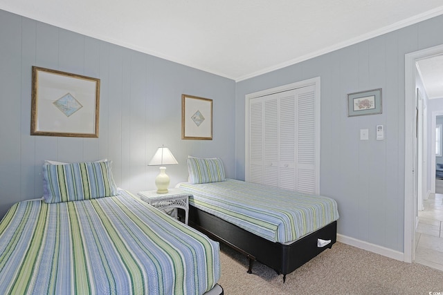 bedroom with a closet, baseboards, and ornamental molding