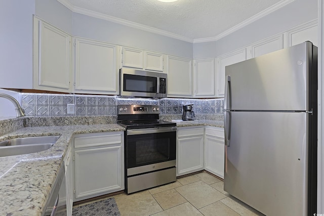 kitchen featuring tasteful backsplash, white cabinetry, stainless steel appliances, and a sink