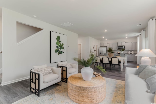 living area featuring wood finished floors, recessed lighting, and baseboards