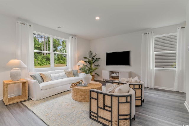 living area with wood finished floors, baseboards, and recessed lighting