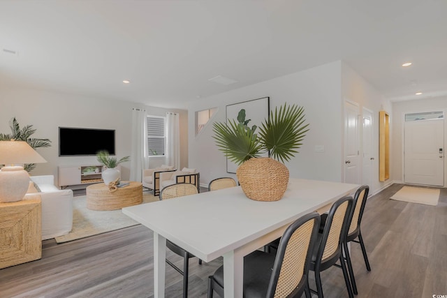 dining area with wood finished floors and recessed lighting