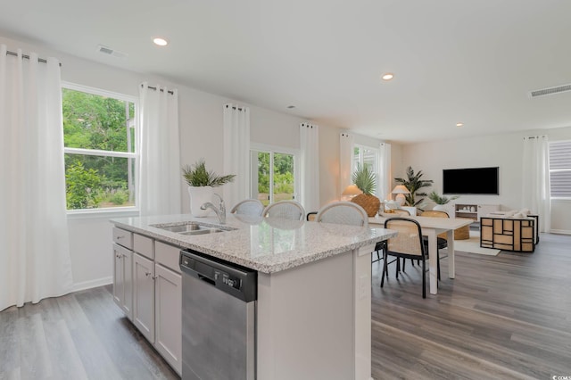 kitchen featuring stainless steel dishwasher, a sink, an island with sink, healthy amount of natural light, and recessed lighting