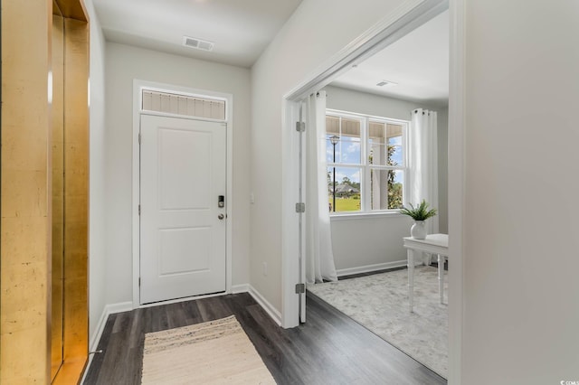 foyer with dark wood-type flooring and baseboards