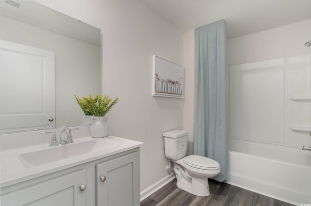full bath featuring wood finished floors, toilet, vanity, shower / bath combination with curtain, and baseboards