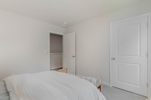 bedroom featuring light colored carpet and baseboards