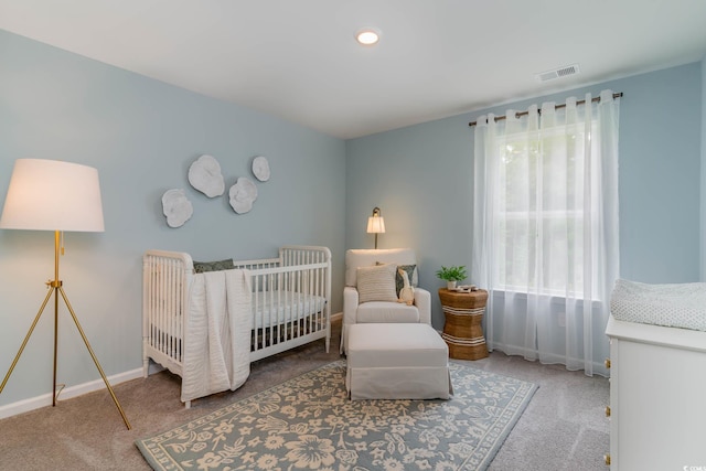 bedroom featuring carpet flooring, a crib, and baseboards