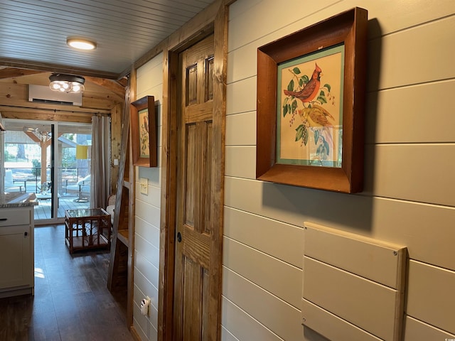 hall featuring dark wood-type flooring and wood walls