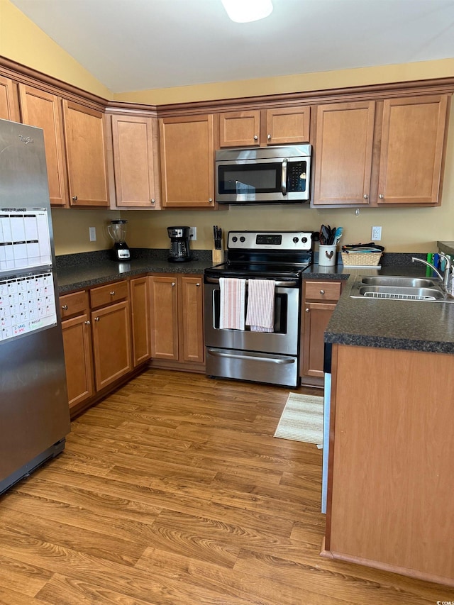 1001 Leatherman Rd, Conway, SC 29527 - kitchen with stainless steel appliances, a sink, wood finished floors, dark countertops, and brown cabinetry