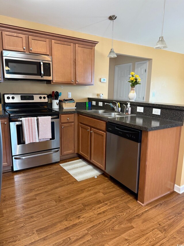 1001 Leatherman Rd, Conway, SC 29527 - kitchen with appliances with stainless steel finishes, a sink, a peninsula, hanging light fixtures, and light wood-type flooring