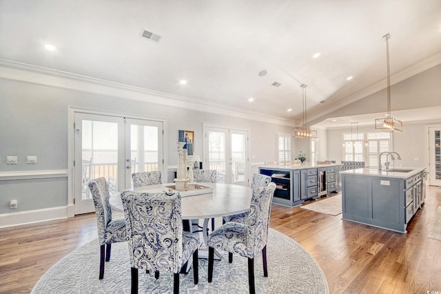 2425 S Bay St, Georgetown, SC 29440 - dining room featuring french doors, wine cooler, ornamental molding, light wood-style flooring, and lofted ceiling