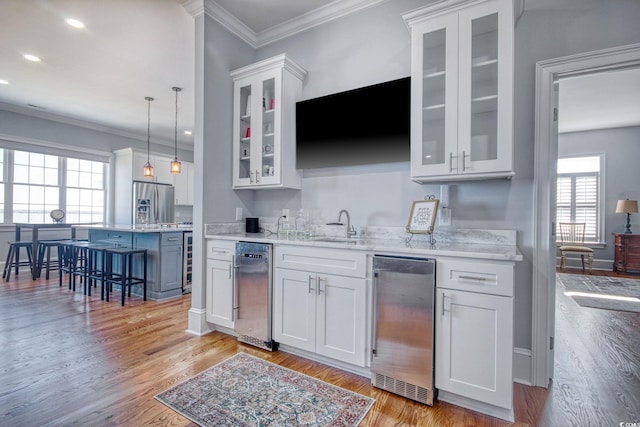 2425 S Bay St, Georgetown, SC 29440 - indoor wet bar featuring stainless steel appliances, light wood-style floors, ornamental molding, decorative light fixtures, and recessed lighting