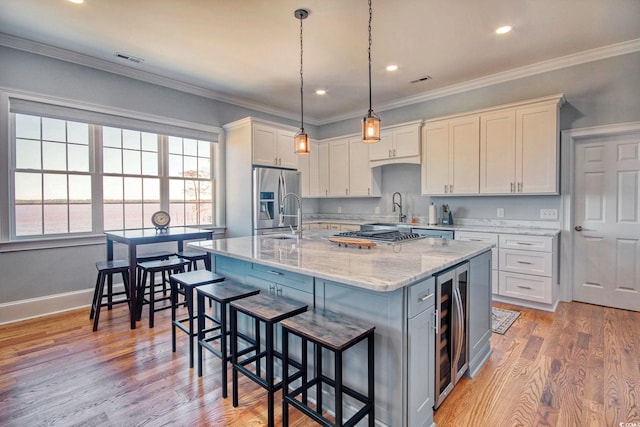 2425 S Bay St, Georgetown, SC 29440 - kitchen featuring stainless steel appliances, beverage cooler, a breakfast bar area, light stone counters, and light wood finished floors