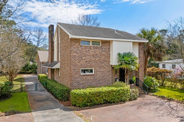 5616 N Kings Hwy, Myrtle Beach, SC 29577 - view of front of property featuring a gate, a chimney, and brick siding