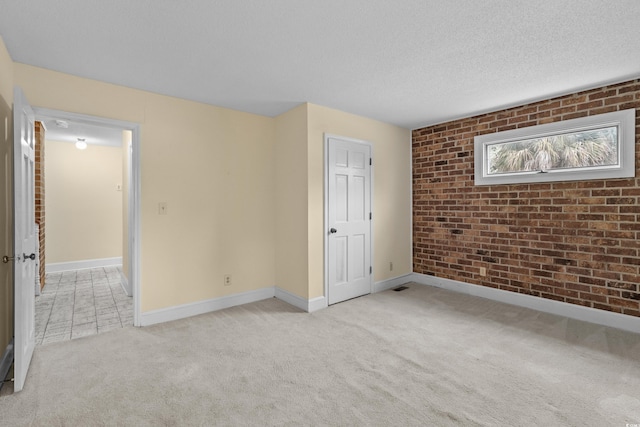 5616 N Kings Hwy, Myrtle Beach, SC 29577 - unfurnished bedroom with brick wall, light carpet, a textured ceiling, and baseboards