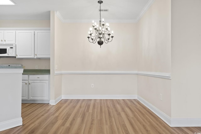 2081 Silvercrest Dr Unit G, Myrtle Beach, SC 29579 - unfurnished dining area featuring light wood-style flooring, a chandelier, crown molding, and baseboards