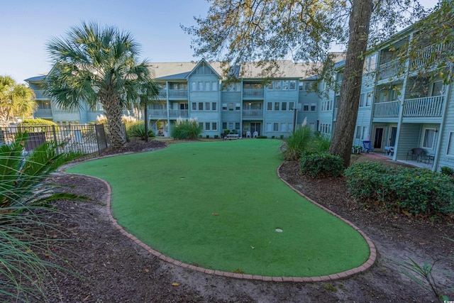 surrounding community with a putting area and fence