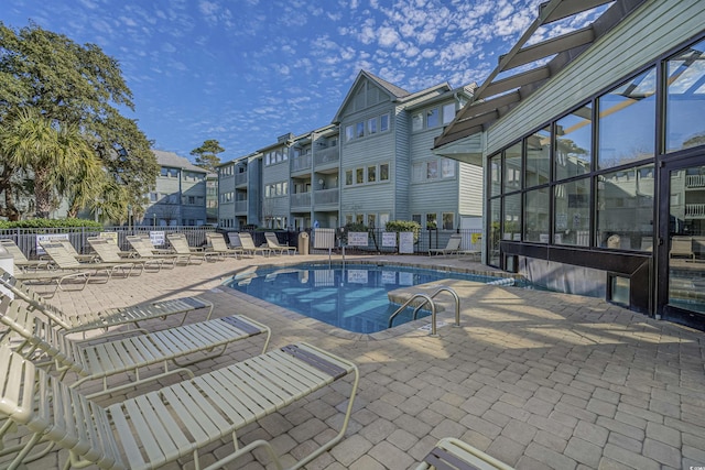 community pool featuring a patio area and fence