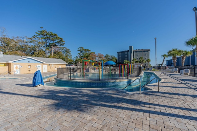 community play area featuring a community pool, a water play area, and fence
