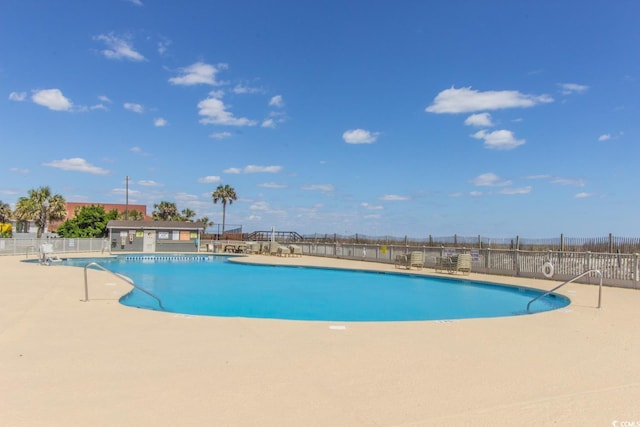 community pool featuring fence and a patio