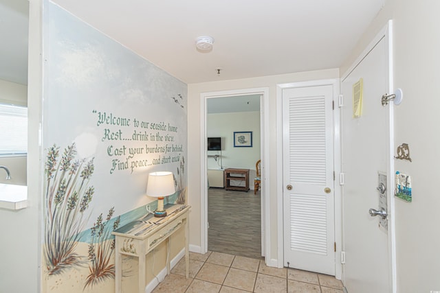 hallway featuring light tile patterned floors and baseboards