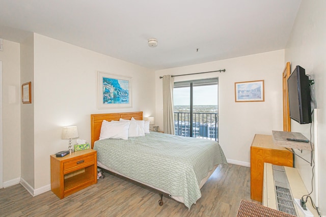 bedroom with access to outside, wood finished floors, and baseboards